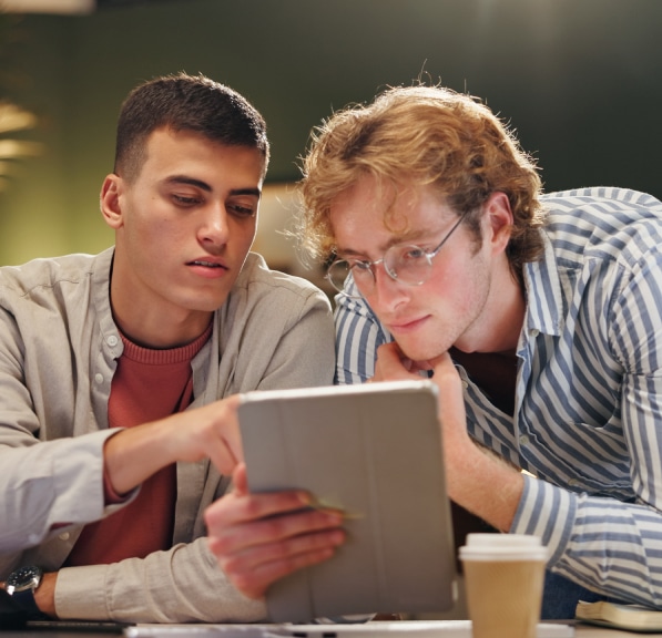 Two young adults collaborating while looking at a tablet